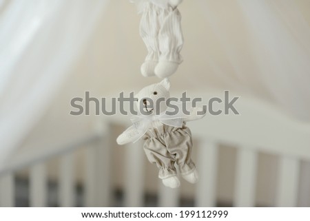 near the crib hanging white teddy bear toy handmade