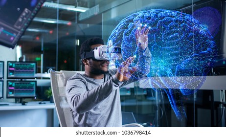 In Near Future Laboratory Scientist Wearing Virtual Reality Headset Sitting in a Chair Using Futuristic Holografic Interface. Modern Brain Study/ Neurological Research Center. - Powered by Shutterstock