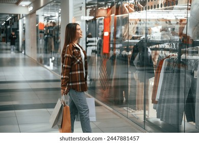 Near glass, in the hall. Woman is shopping in the supermarket. - Powered by Shutterstock