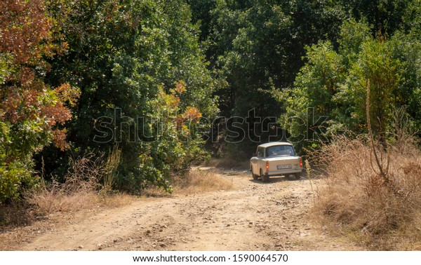 Near Vinica / North Macedonia - 23 August\
2019: Vintage Russian Trabant cars, part of a classic car holiday\
convoy, go off-road and navigate a high pass on rough dirt tracks\
through wooded hillsides.