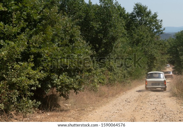 Near Vinica / North Macedonia - 23 August\
2019: Vintage Russian Trabant cars, part of a classic car holiday\
convoy, go off-road and navigate a high pass on rough dirt tracks\
through wooded hillsides.