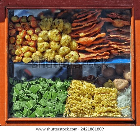 A neat arrangement in the glass display case of meatballs, fried dumplings or pangsit goreng to complement bakso malang dishes