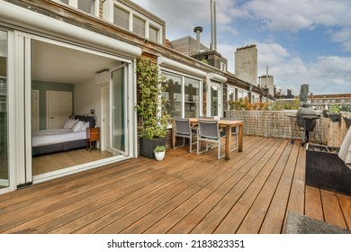 Neat Paved Patio With Sitting Area And Small Garden Near Wooden Fence