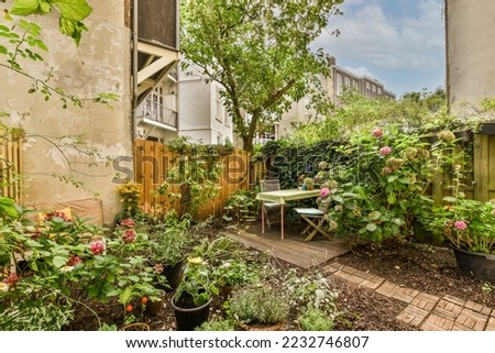 Neat powerful patio with sitting area and small garden near wooden fence