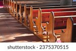 A neat row of polished wooden pews fills the church