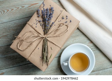 Neat Stack Of Books With Craft Paper Covers, Wrapped In Rope And Decorated With Lavender Flowers, And A Cup Of Tea On A Wooden Table. Concept Of A Cozy Atmosphere For Reading. Top View.