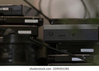A neatly arranged stack of multiple hard drives is positioned on top of each other on a table, showcasing their technological design