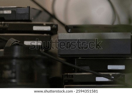 A neatly arranged stack of multiple hard drives is positioned on top of each other on a table, showcasing their technological design