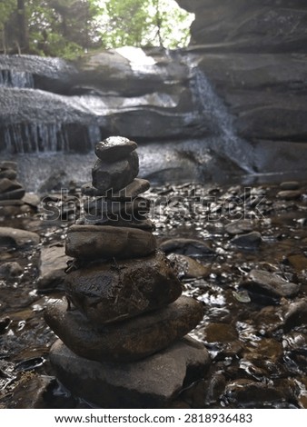 A neatly balanced stack of flat stones positioned near a flowing stream.