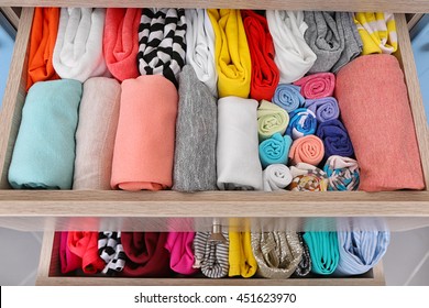 Neatly Folded Clothes In Chest Of Drawers