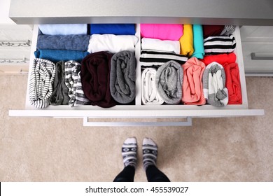 Neatly Folded Clothes In Chest Of Drawers