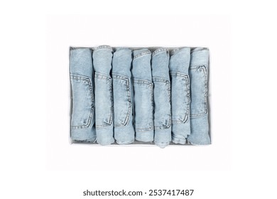 Neatly Folded Light Blue Denim Jeans Collection in Storage Box, Organized Clothing Drawer with Rolled Pants, Marie Kondo Style Wardrobe Organization - Powered by Shutterstock