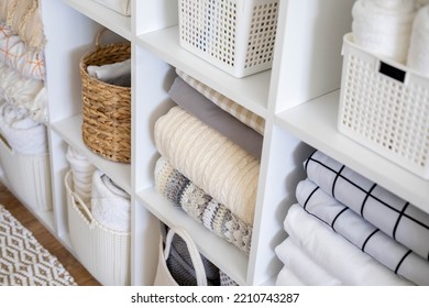 Neatly folded linen cupboard shelves storage at eco friendly straw basket placed closet organizer drawer divider. Stacks towels pillows plaids soft sheets bedding cabinet filling Nordic organization - Shutterstock ID 2210743287