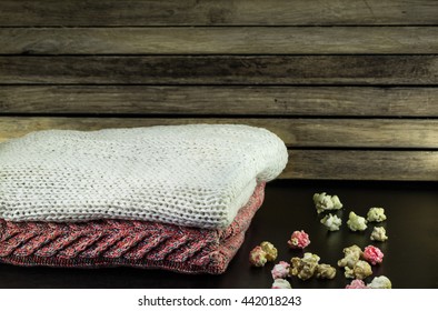 neatly folded sweaters on a wooden background with decoration
