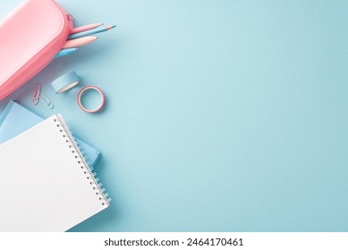 A neatly organized display of school supplies on a light blue background, featuring notebooks, pencils, and tapes for an inspiring educational setup - Powered by Shutterstock