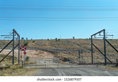 Nebo, Queensland, Australia - October 2019: Railway Crossing With High Voltage Power Lines Warning