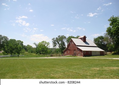 Nebraska Landscape With Farm House On A Grassy Field In Between Trees