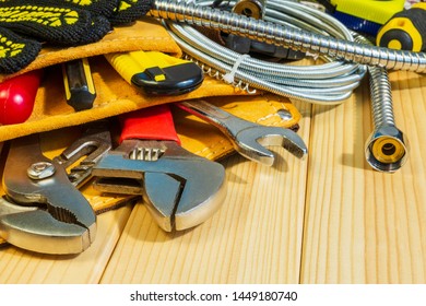 Necessary set of tools in the bag for plumbers on a wooden background. Indispensable for master.