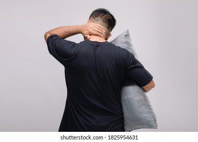 Neck Aches Concept : Portrait Asian Man Holding Grey Pillow And Feeling Tired Or Aches On His Neck. Studio Shot Isolated On Grey Background