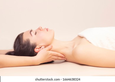 neck massage in a spa salon for a girl. concept of health massage. light background.