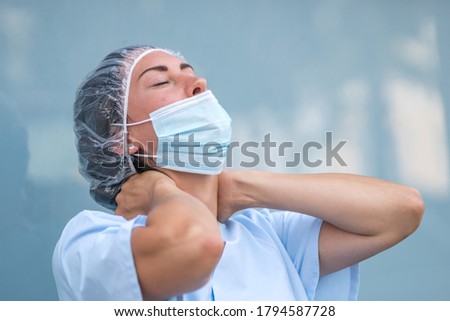 Neck muscle strain. Portrait of a tired and suffering doctor woman massaging her painful neck