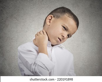 Neck Pain. Portrait Stressed Unhappy Child Boy With Back Pain, After Long School Hours Studying Isolated Grey Wall Background. Negative Human Emotions Facial Expression Feeling. Wrong Position At Desk