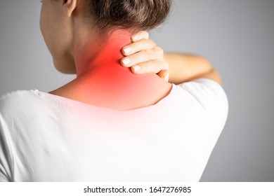 Neck pain, woman with backache on gray background, studio shot