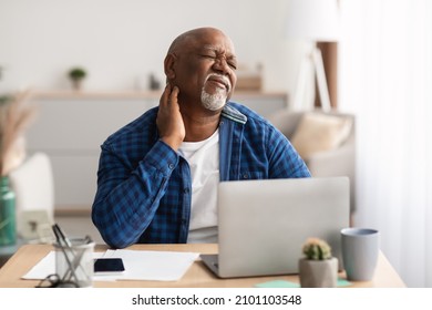 Neckache. Senior African American Man Touching Aching Neck Suffering From Pain Sitting Working On Laptop In Modern Office. Healthcare, Health Problems In Older Age Concept - Powered by Shutterstock