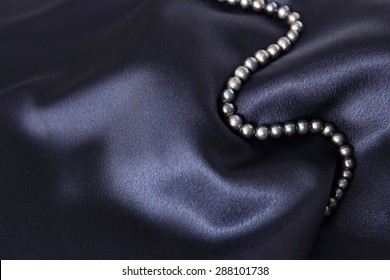 Necklace Black Pearl On A Blue Background