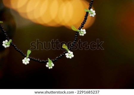 Necklace with green and black beads and white flowers. Beaded beads. Lovely stylish beads.