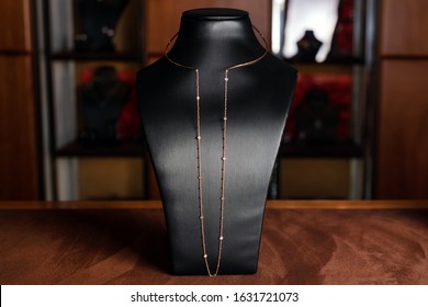 Necklace Made Of Gold With Diamonds On A Stand In Fashion Jewelry Boutique. Black Stand Neck With Luxury Jewelry, Women Accessories In Store Window.
