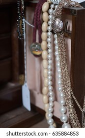 Necklaces Hanging From The Door Of A Jewlery Box In An Antique Store