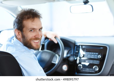 Need A Ride? Bearded Mature Man Smiling To The Camera Over His Shoulder While Sitting In His New Car With His Hand On The Steering Wheel Copyspace 