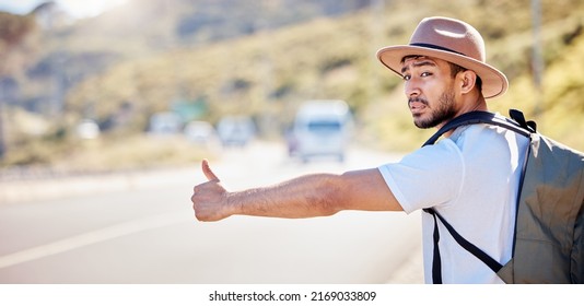 I Need To Find My Way Around. Shot Of A Young Man Hitchhiking On The Side Of The Road.