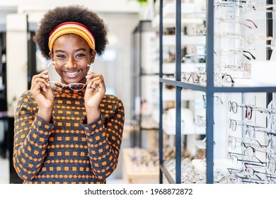 Need a new glasses. Young woman african american in optic store choosing a new eyeglasses frame. Medical, health care concept, used correct or assist defective eyesight