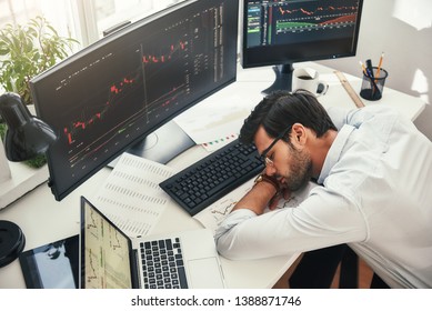 I need to relax. Tired young bearded trader in formal wear sleeping on the desk while working late in his modern office - Shutterstock ID 1388871746