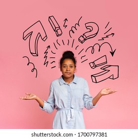 I Need Some Help. Puzzled African Teen Girl With Arms Wide Open And Graphic Symbols Above Over Pink Studio Background