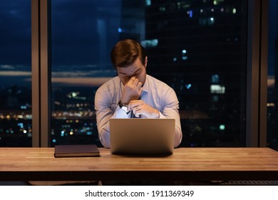 Need some rest. Overworked young man ceo manager take break in online work close tired eyes rub nose bridge. Busy office employee suffer from chronic dry eye syndrome spending hours in front of laptop - Shutterstock ID 1911369349