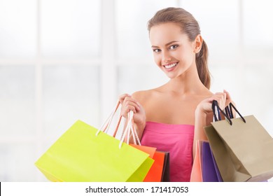 I Need Some Retail Therapy. Attractive Young Woman Holding Shopping Bags And Smiling At Camera