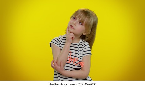 Need To Think. Doubting Pensive Little Blonde Teen Child Kid Girl Pondering And Imagining In Mind, Wondering Difficult Solution, Feeling Confused, Not Sure About Choice On Yellow Studio Background