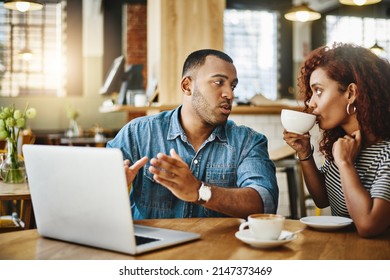 I Need Your Input On This. Cropped Shot Of A Young Couple Working On A Laptop While Sitting In A Coffee Shop.