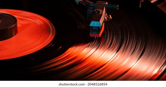 Needle detail on vinyl record on turntable, low light image with reflection - Powered by Shutterstock