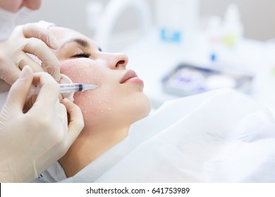 Needle mesotherapy in beauty spa salon or clinic. Cosmetics been injected to woman's face, close up portrait