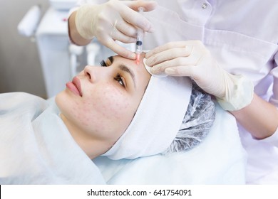 Needle mesotherapy in beauty spa salon or clinic. Cosmetologist inject to woman's face botox and collagen