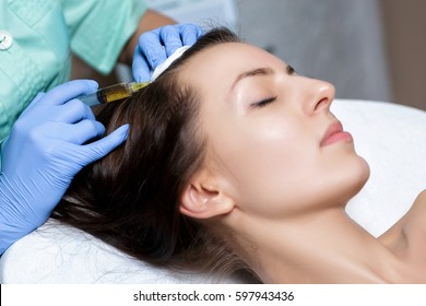 Needle mesotherapy. Cosmetic been injected in woman's head. Thrust to strengthen the hair and their growth