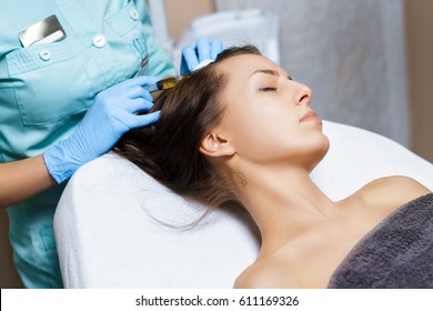 Needle mesotherapy. Cosmetic been injected in woman's head. Thrust to strengthen hair and their growth