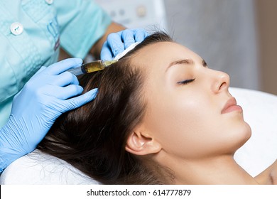 Needle mesotherapy. Cosmetic been injected in woman's head. Thrust to strengthen hair and their growth