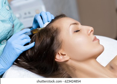 Needle mesotherapy. Cosmetic been injected in woman's head. Thrust to strengthen the hair and their growth