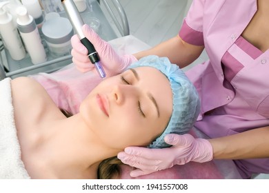 Needle mesotherapy. Cosmetologist performs needle mesotherapy on a womans face. Beautiful woman receiving microneedling rejuvenation treatment. Needle lifting