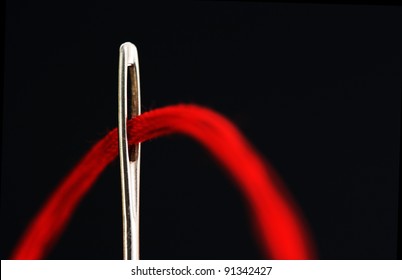 Needle With A Red Thread On A Black Background